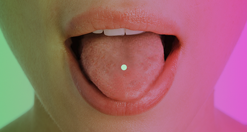 Place a FEMLYV tablet on the tongue.