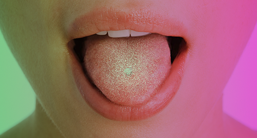 Place a FEMLYV tablet on the tongue.